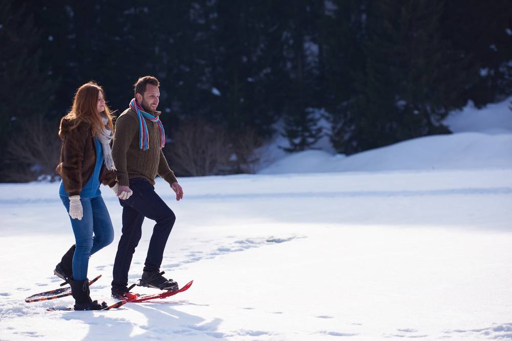 a couple enjoying snowshoeing while visiting the best places to stay in the Poconos